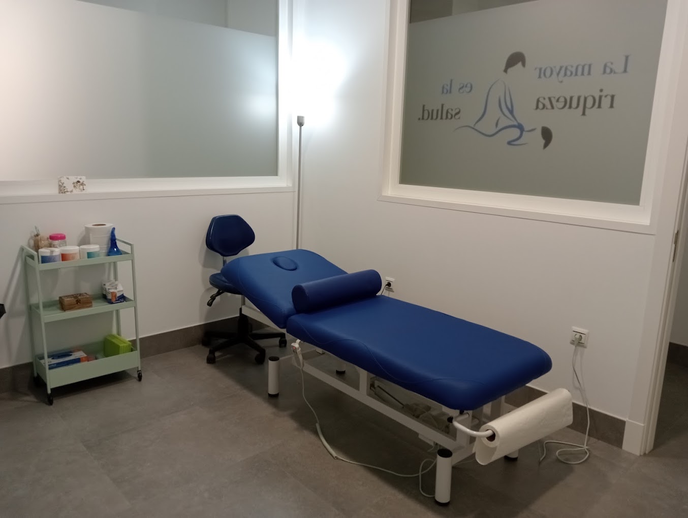 Camilla eléctrica de fisioterapia azul navy con carrito de material.