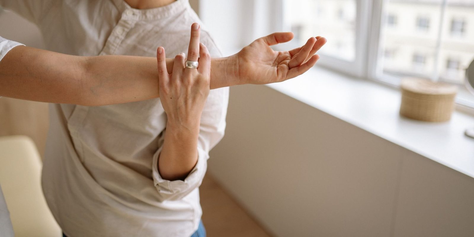 Fisioterapeuta guiando la movilidad del brazo y la muñeca de una paciente.