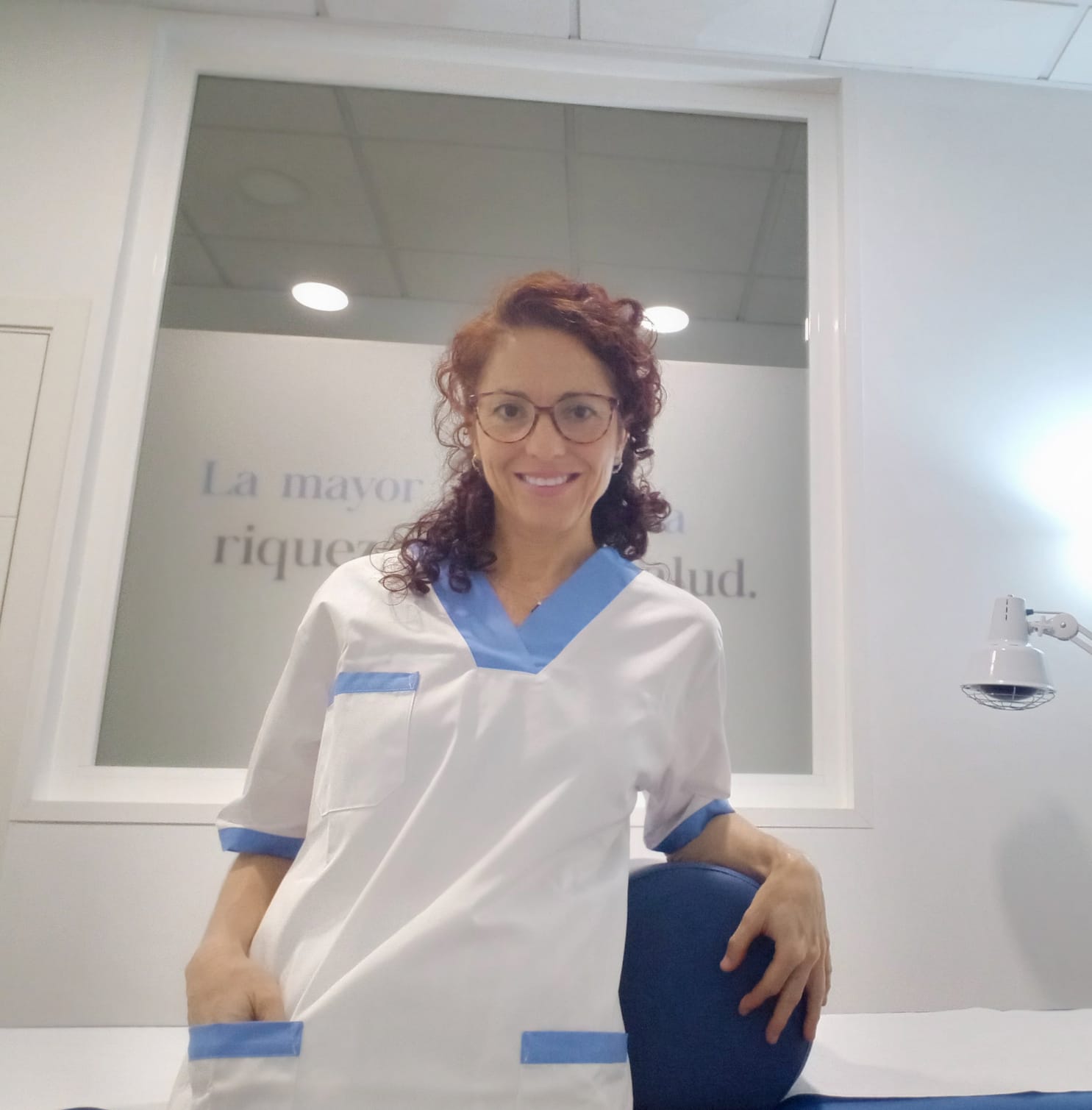 Virginia G. Guerra en su consulta, delante del mural con el lema de la clínica.